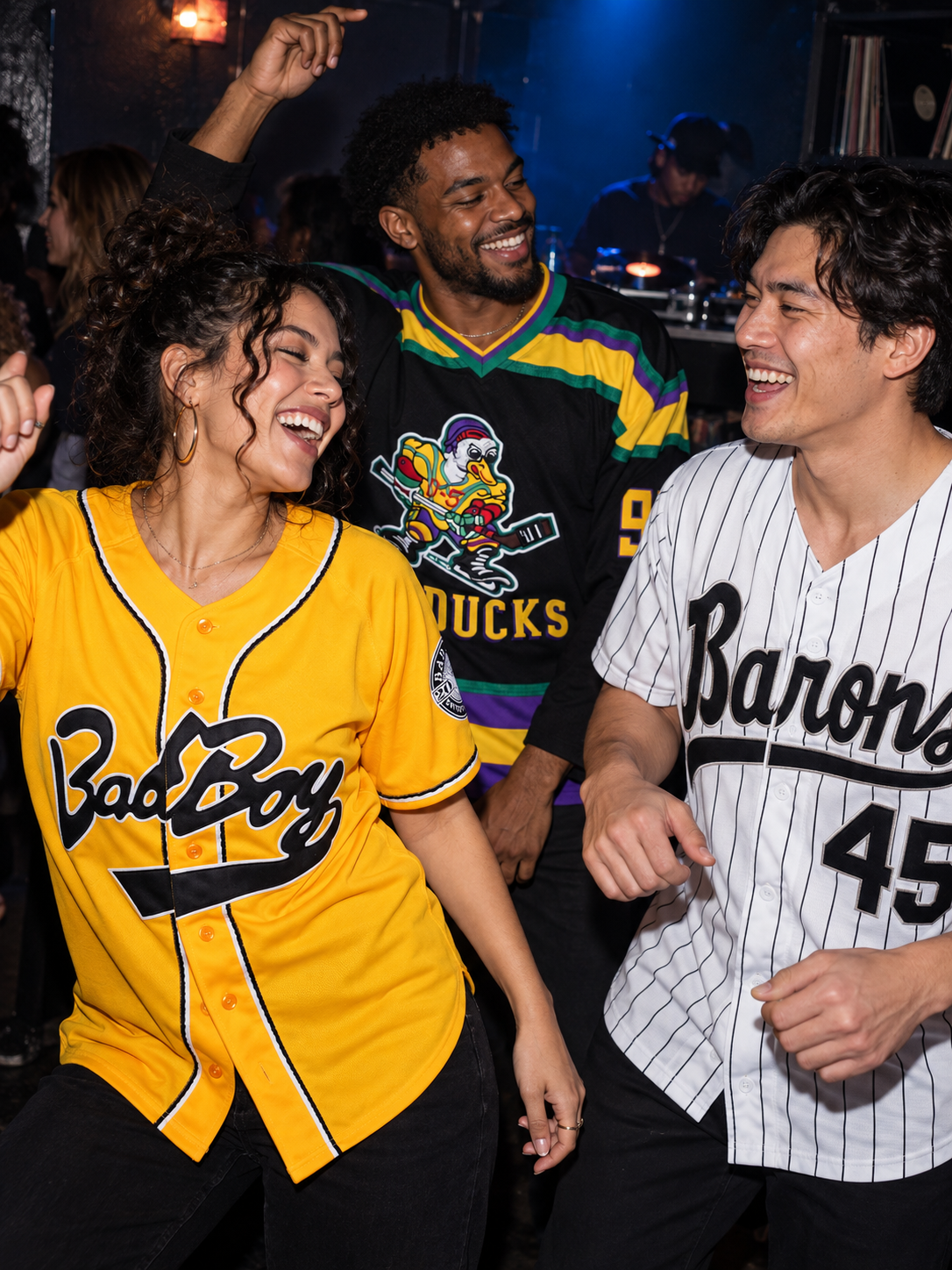 Friends in baseball jerseys laughing together at a music party